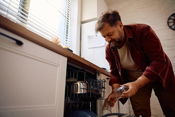 a man loading a dishwasher