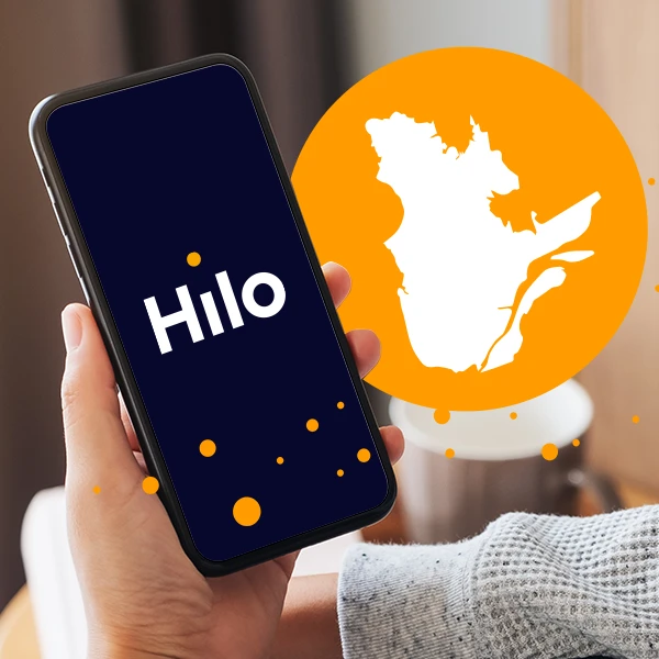 Une main tenant un téléphone affichant “Hilo” sur fond bleu, avec une carte blanche du Québec dans un cercle orange en arrière-plan.